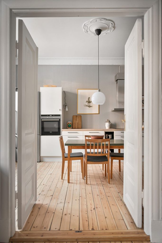 Ancien parquet en pin vu depuis une porte ouverte sur la cuisine